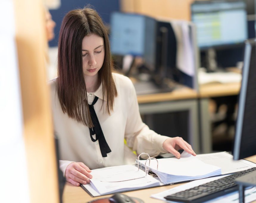 KR Group office employee working at their desk, looking through a folder.