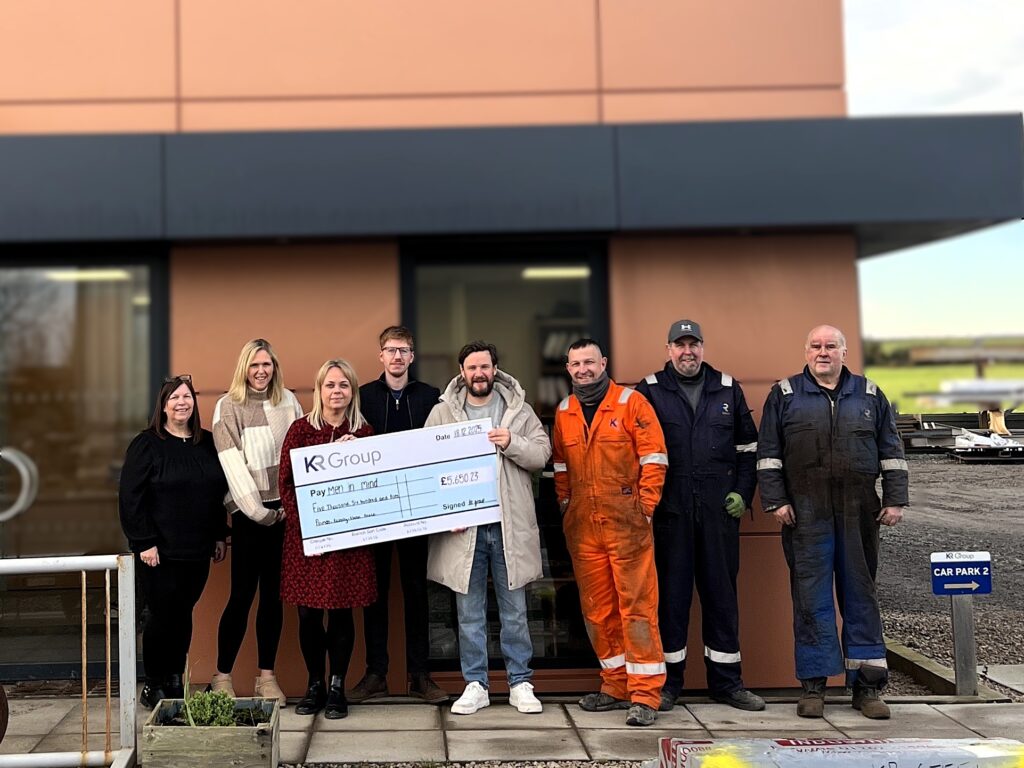KR Group presenting their charity of the year, Men in Mind with a fundraising cheque outside KR Group's office and workshops in Newburgh, Aberdeenshire.