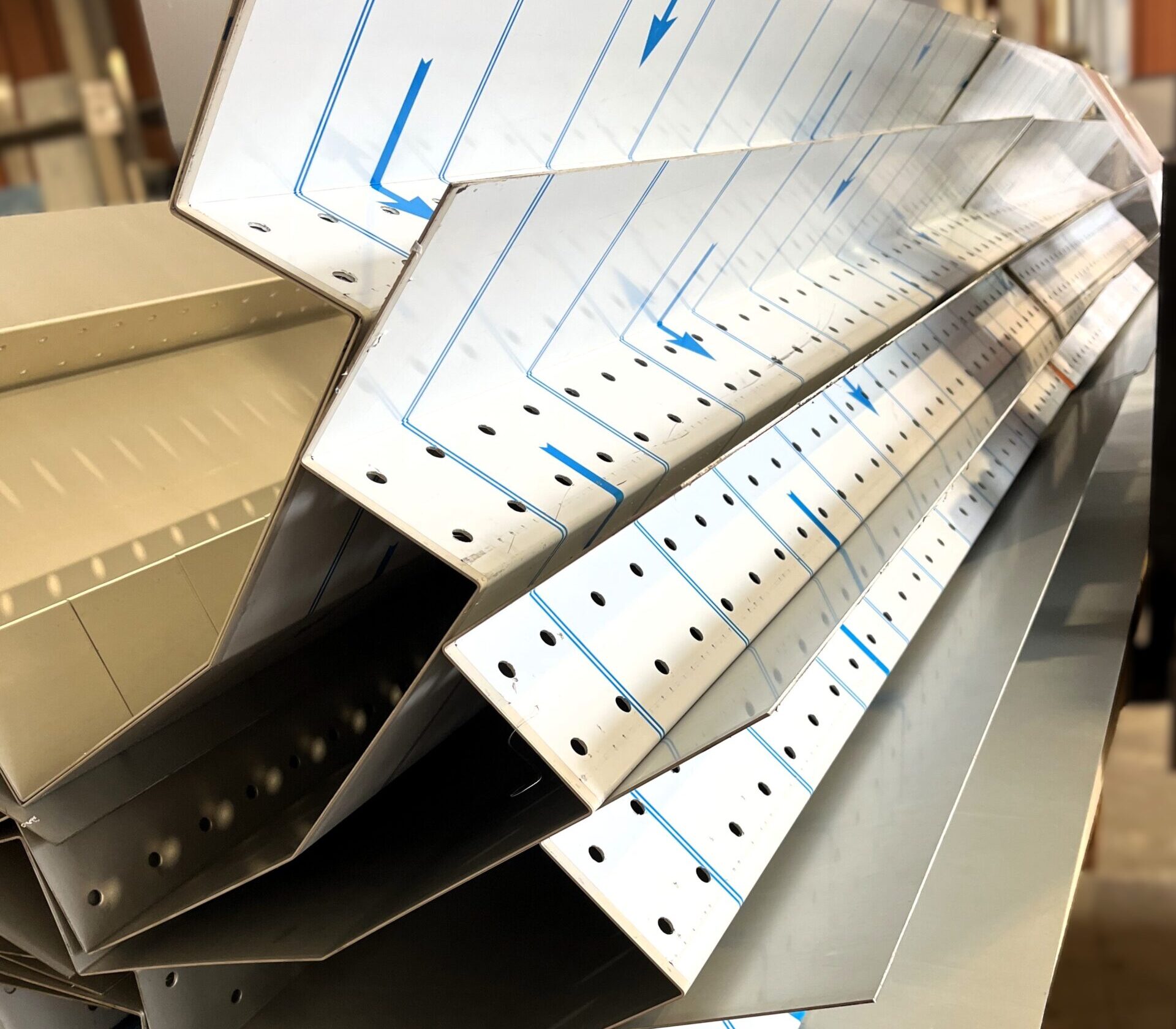 Sheet metal ventilated ridges stacked in KR Group's workshop.